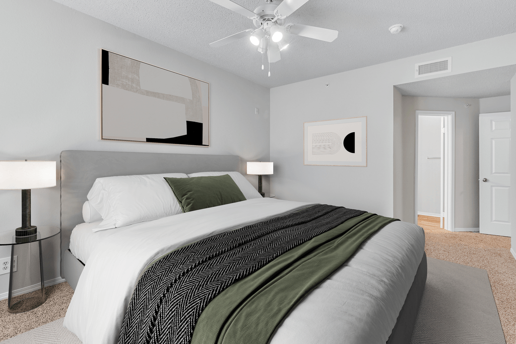 a spacious bedroom with a large bed and a ceiling fan