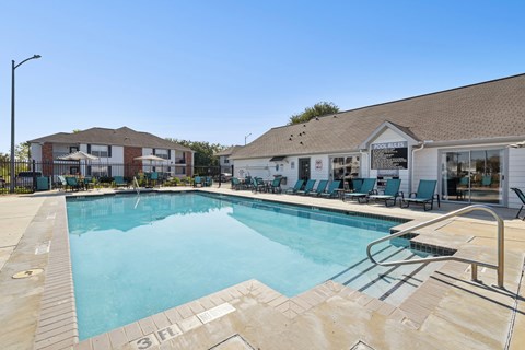 A large swimming pool with a slide and lounge chairs.