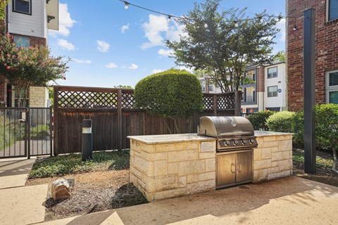 A backyard with a BBQ grill and a small garden.