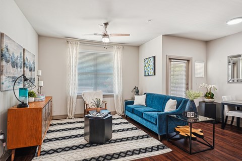 A living room with a blue couch and a wooden side table.