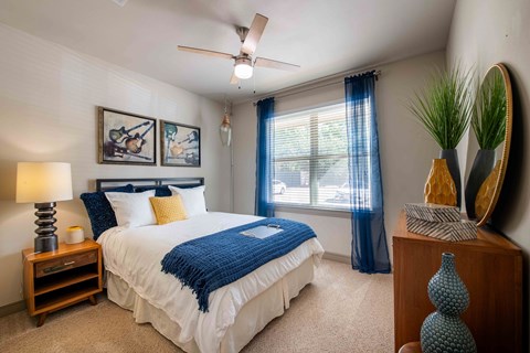 A bedroom with a large bed and a ceiling fan.