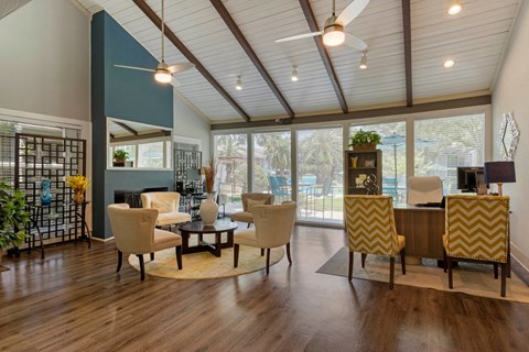 A living room with a white sofa and yellow and white striped chairs.