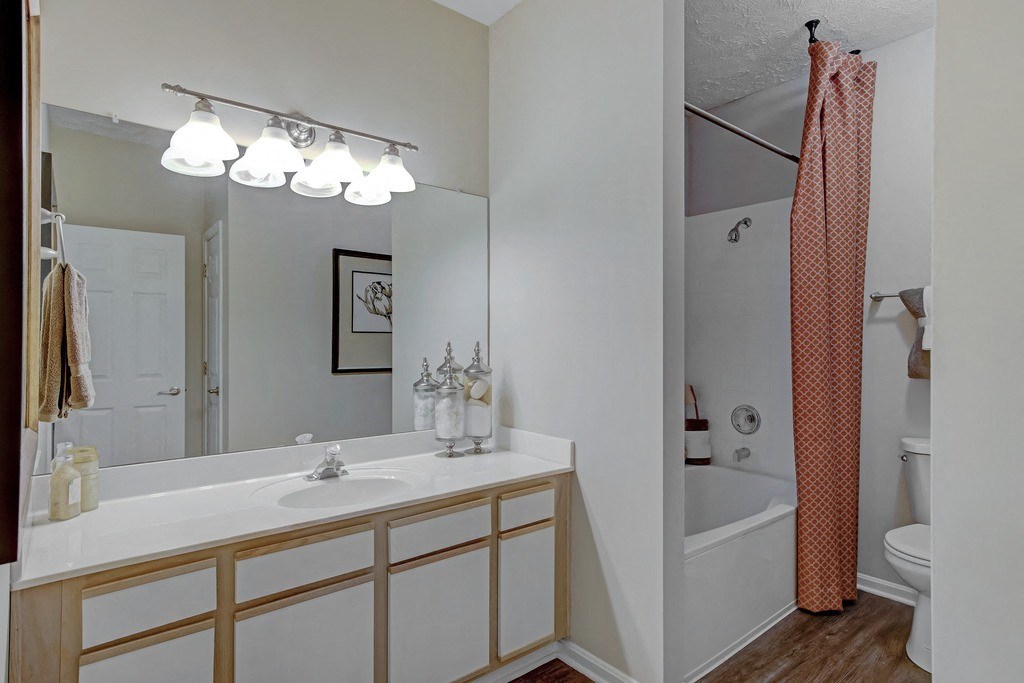 a bathroom with a large mirror and a sink and a tub