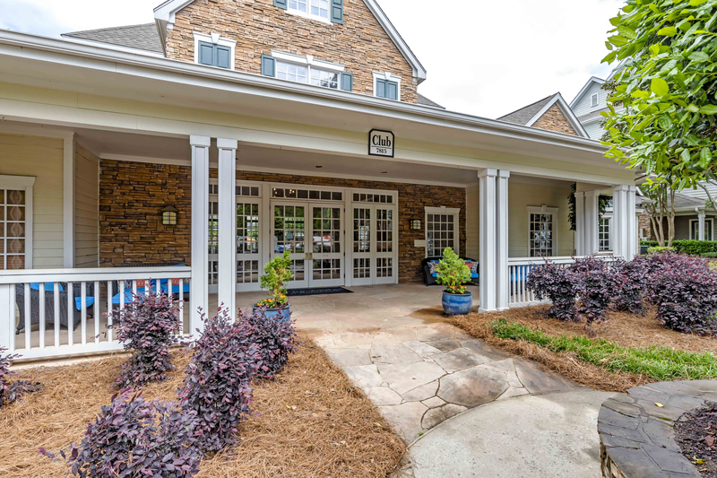 the front porch of a house with a walkway and a porch swing