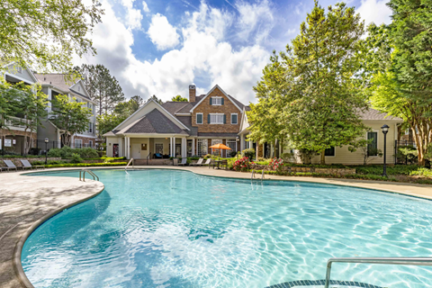 a large swimming pool with a house in the background