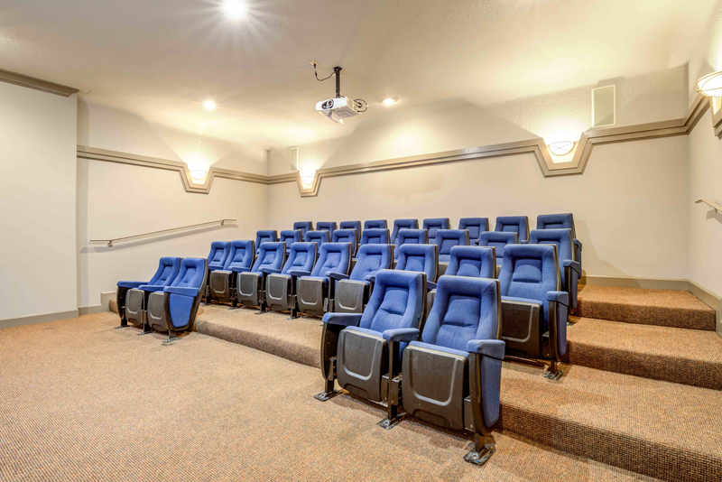 theater room with blue chairs in a room with stairs
