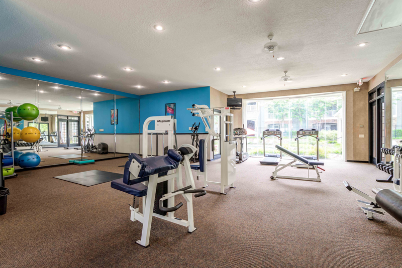 a gym with weights and cardio equipment and a window