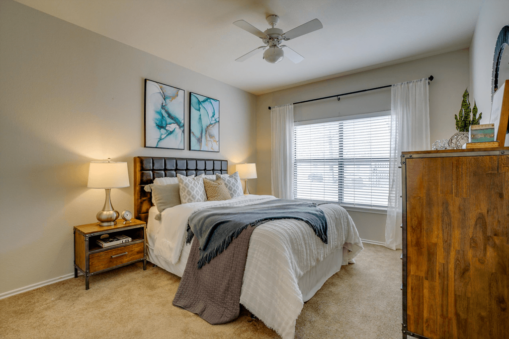 a bedroom with a bed and a ceiling fan