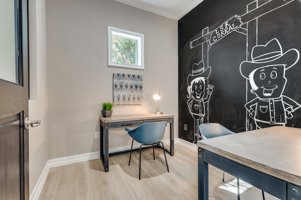a home office with a chalkboard wall and a desk with a chair