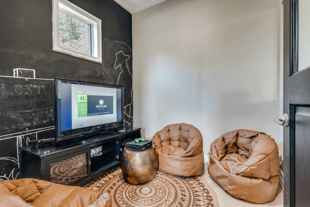 a living room with couches and a tv and a black wall