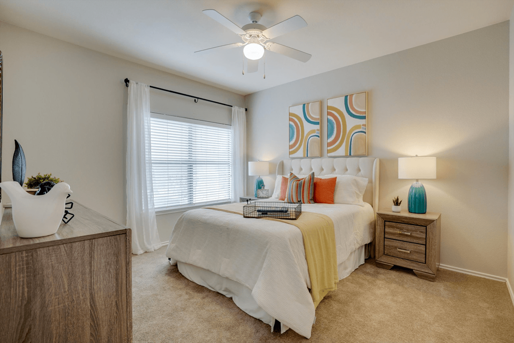 a bedroom with a bed and a ceiling fan