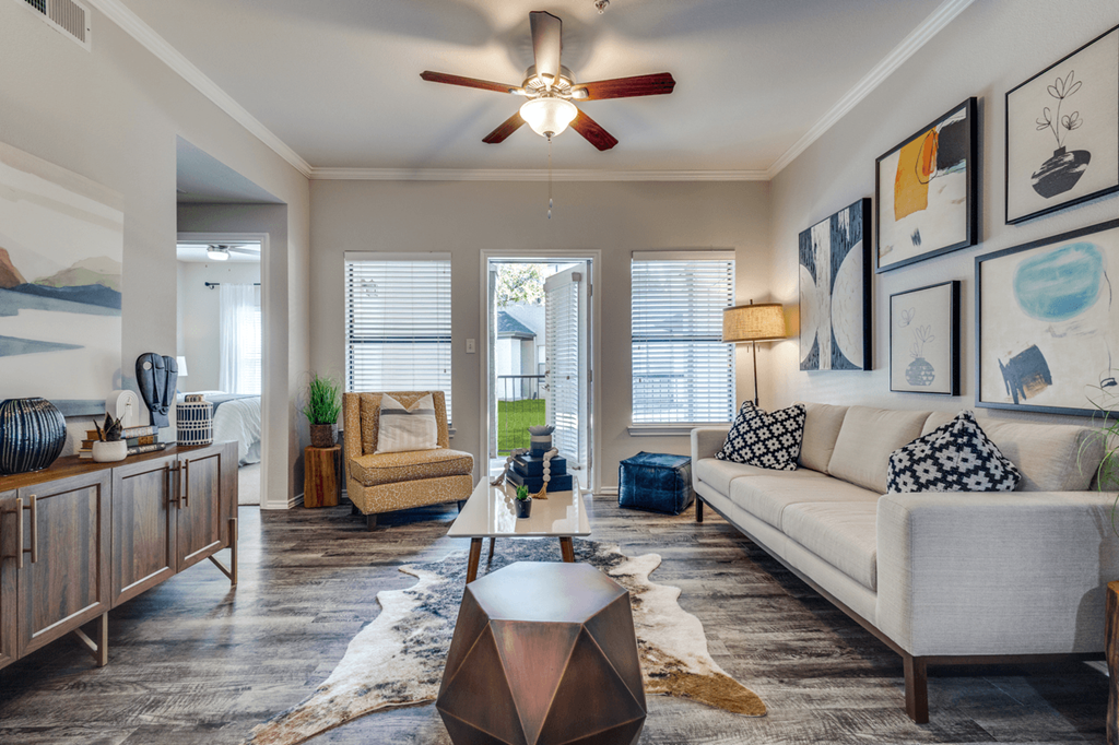 a living room with a white couch and a ceiling fan