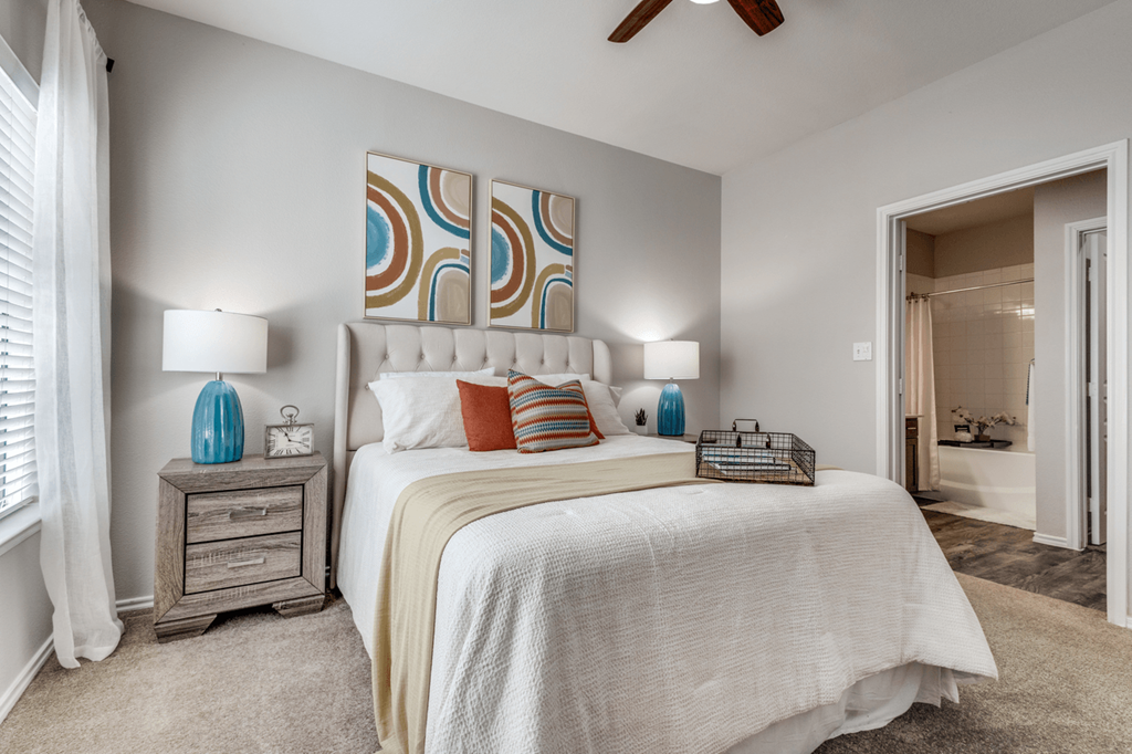 a bedroom with a large bed and a ceiling fan