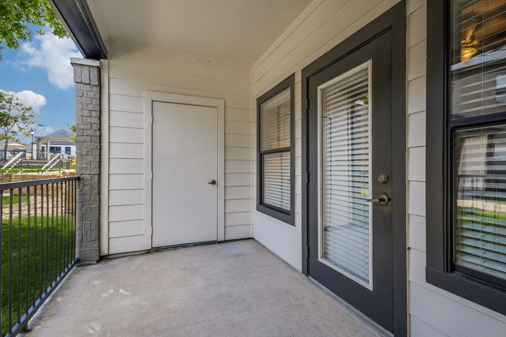 the front porch of a house with a white door and windows