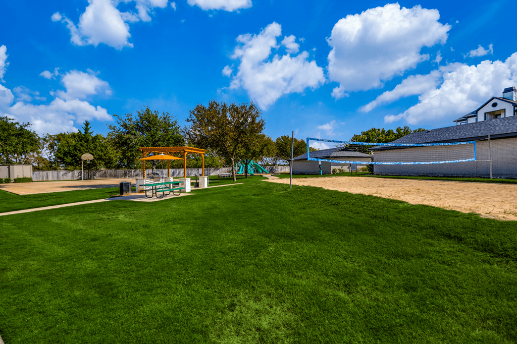 a park with a playground and a volleyball court