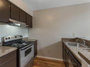 Kitchen with Brown Cabinets Stainless Steel Appliances and Grey Counters