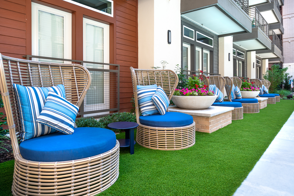 Outdoor seating area with artificial turf and building exterior surrounding
