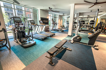 Fitness center with cardio and strength machines and wall mounted television - Photo Gallery 82