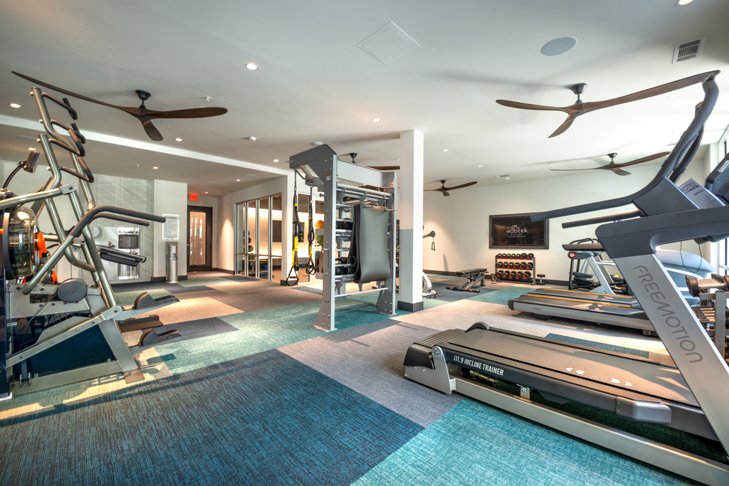 Fitness center with cardio and strength machines and wall mounted television