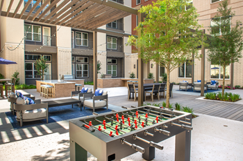 Courtyard outdoor gaming area with foosball table, alfresco seating with gas grill area and pergolas - Photo Gallery 13