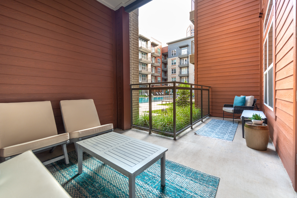 Staged private patio with chairs, table and outdoor rugs