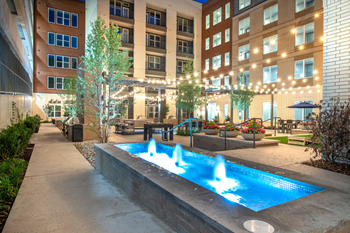 Fountain water feature near courtyard lounge and outdoor gaming area with native landscape - Photo Gallery 7