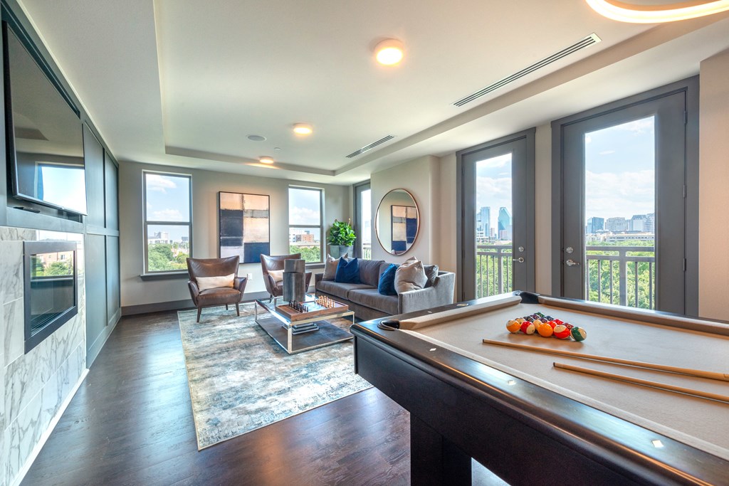 Resident sky lounge facing a pool table and sitting area complete with a television and fireplace.