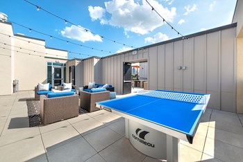 Outdoor sitting area next to a ping pong table and grilling area - Photo Gallery 9