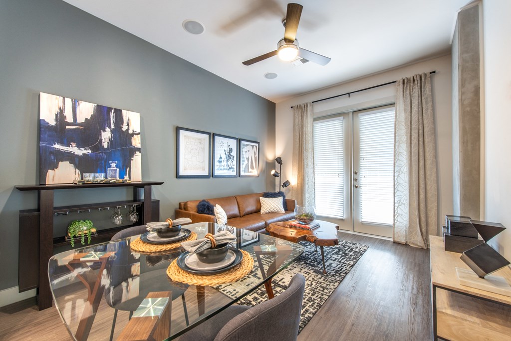 Interior of apartment living area facing exterior windows and a couch facing a television