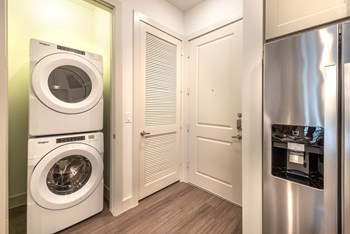 Entry way of apartment facing in-unit washer and dryer and fridge in the kitchen - Photo Gallery 38