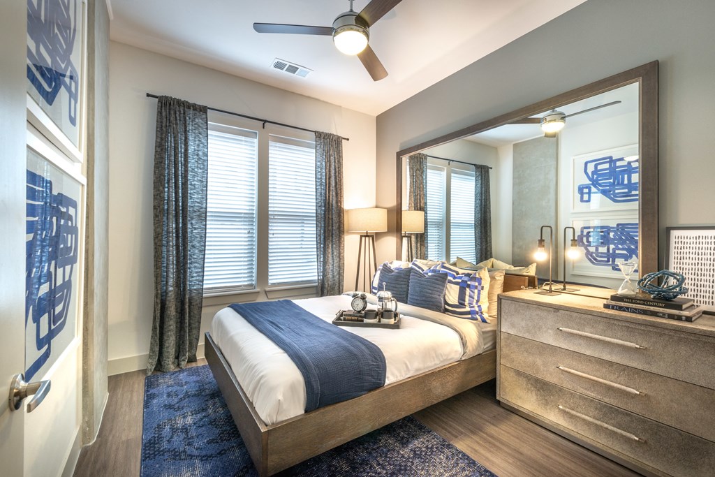 Bedroom facing a bed and large bedside table next to an exterior window.