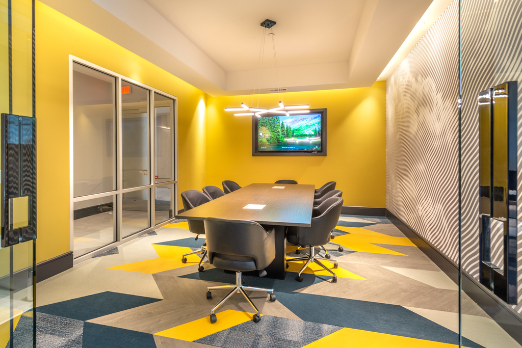 Private conference room with long table, chairs and wall mounted television