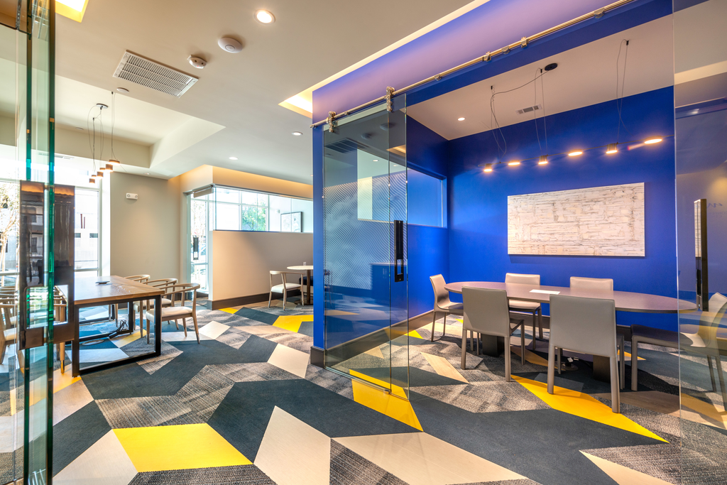 Clubhouse lounge with glassed private conference room with table and chairs