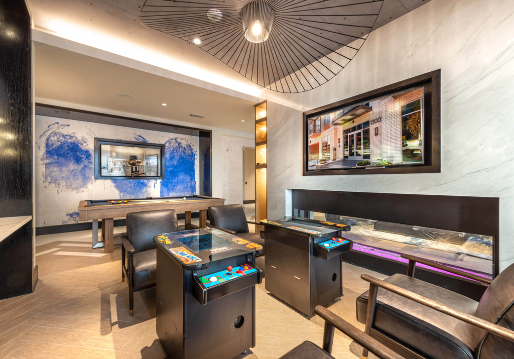 Clubhouse game room with arcade, wall mounted televisions, fireplace and pool table