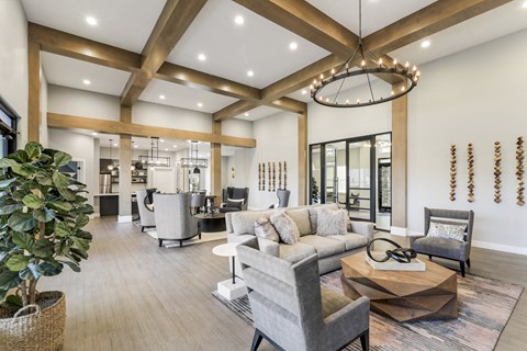 A modern living room with a large grey sofa and a wooden coffee table.
