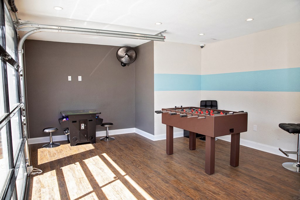 game room with a foosball table and a bar stool.