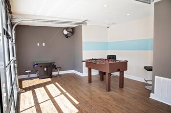 game room with a foosball table and a bar area.