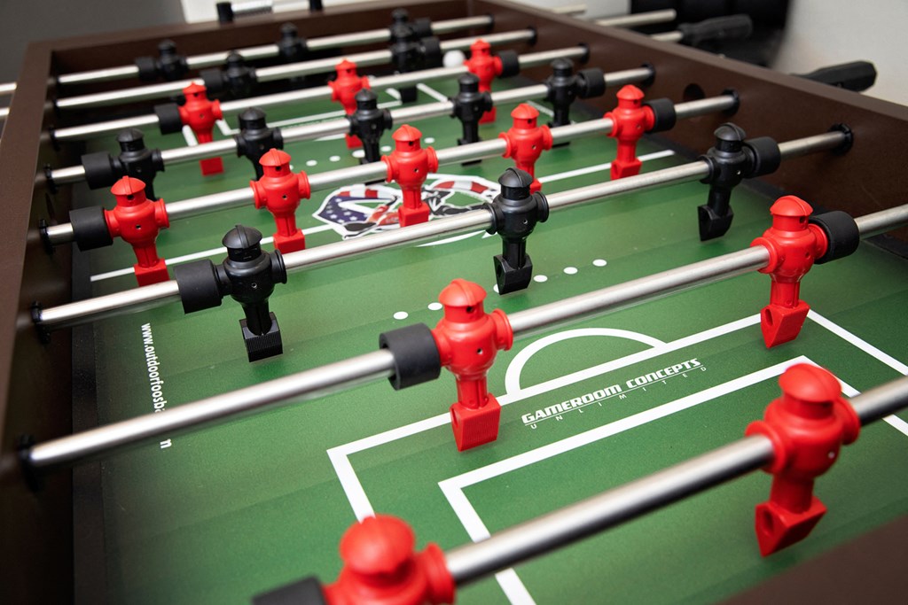 A foosball table with red and black players.