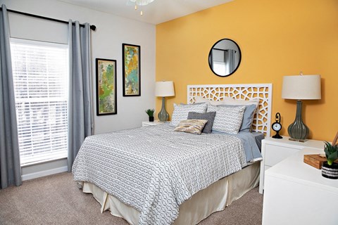 A bedroom with a bed, nightstand, and two lamps.