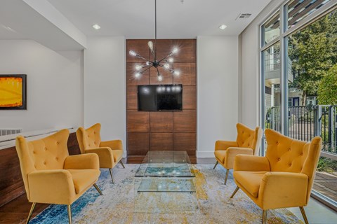 A living room with yellow chairs and a flat screen TV.