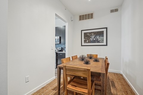 A dining room with a wooden table and chairs.