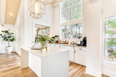 a kitchen with large windows and a large white island