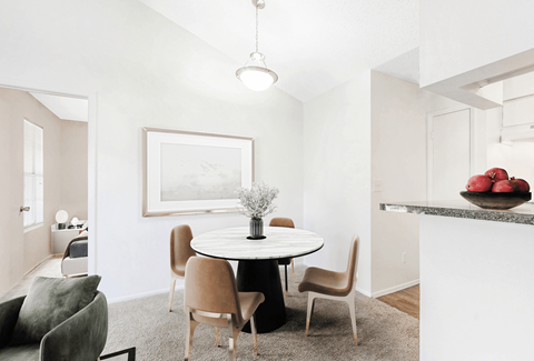 a dining area with a round table and four chairs
