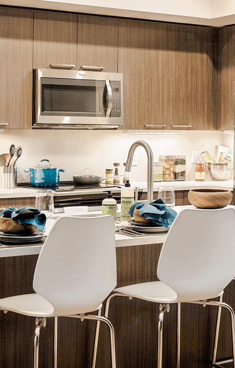 Two white chairs are placed in front of a kitchen counter.