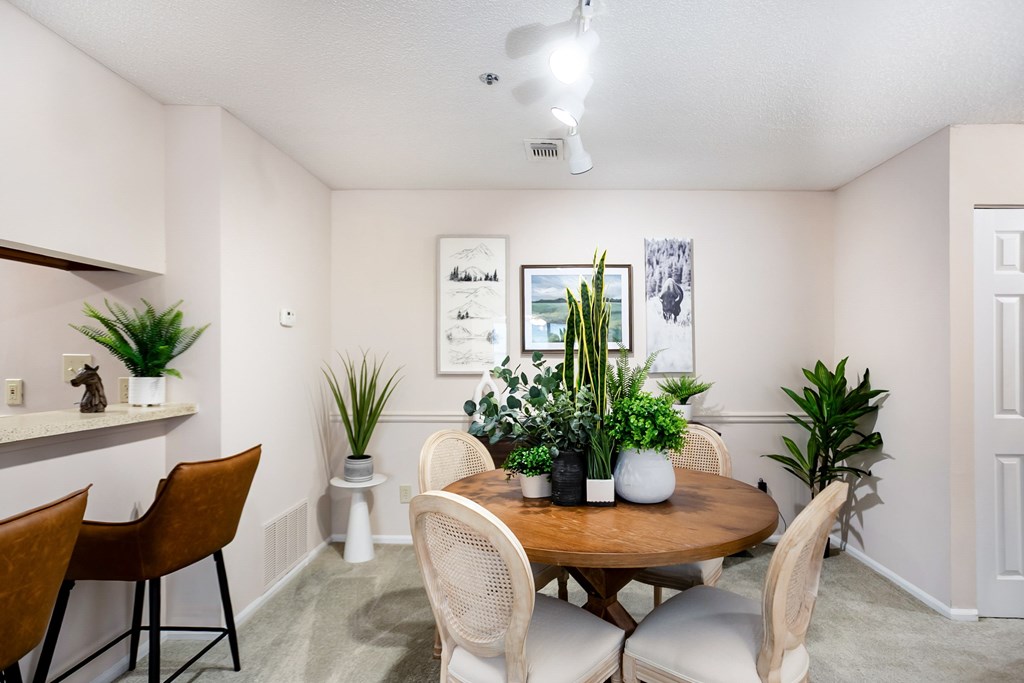 A dining room with a wooden table surrounded by chairs.