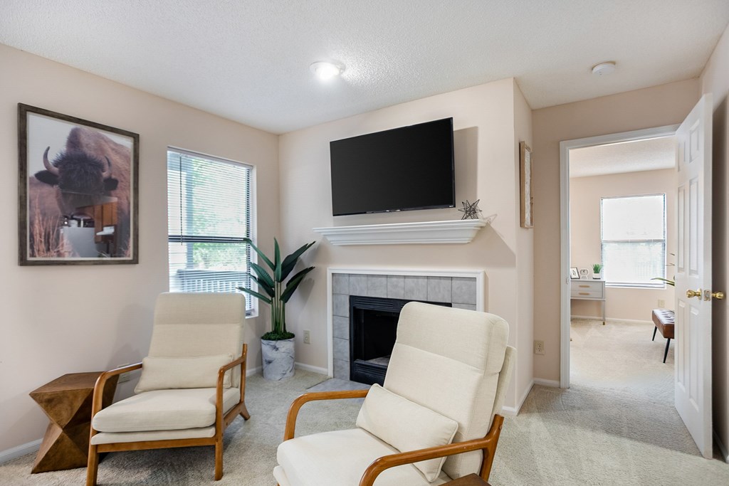 Two chairs are placed in front of a fireplace in a living room.