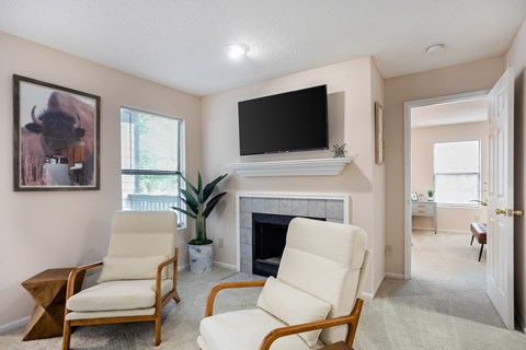 Two chairs are placed in front of a fireplace in a living room.