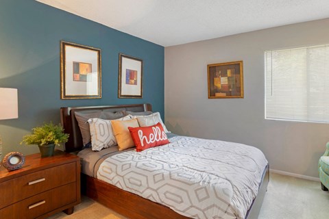 Model Bedroom with Bed and Nightstand Against Blue Accent Wall