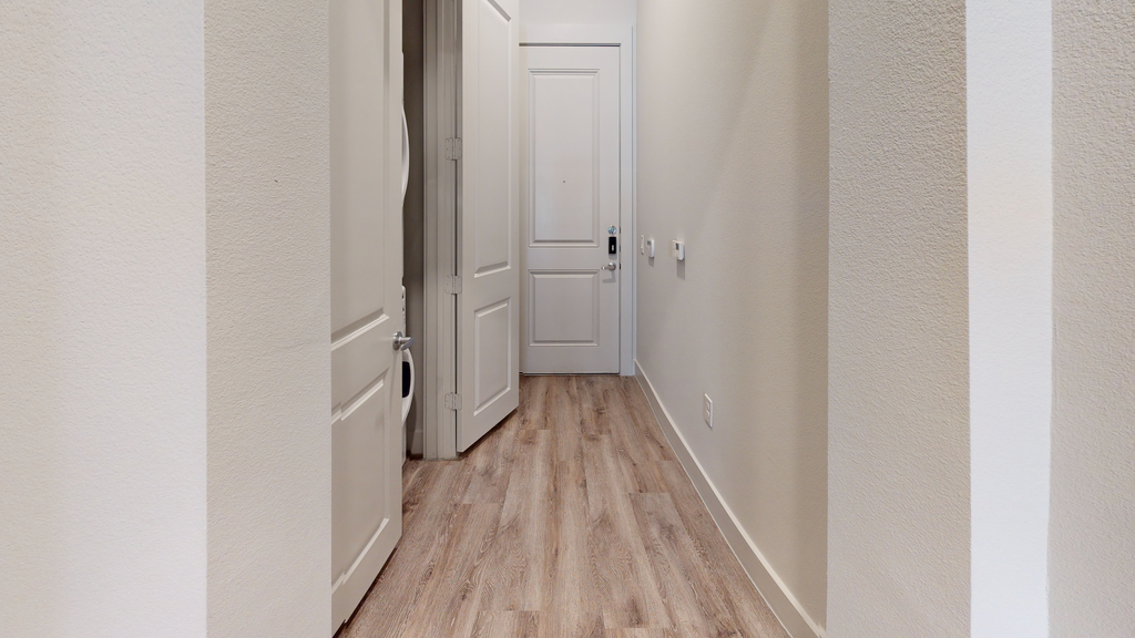 Entry way with wood style flooring and closet with washer and dryer