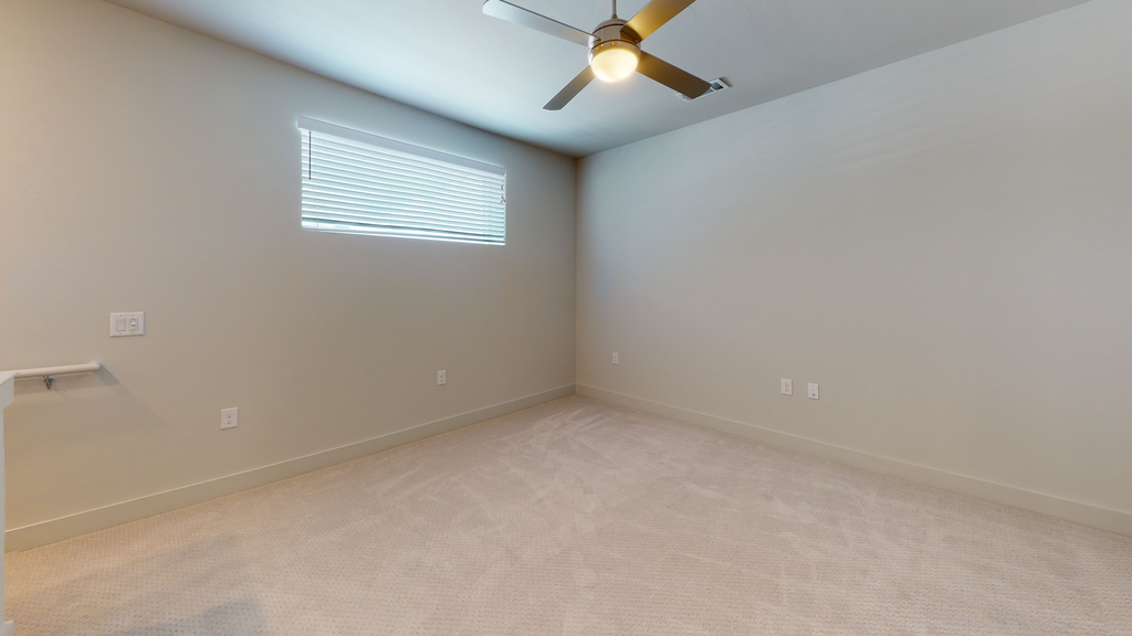 Bedroom with carpet, ceiling fan with light and long window with blinds